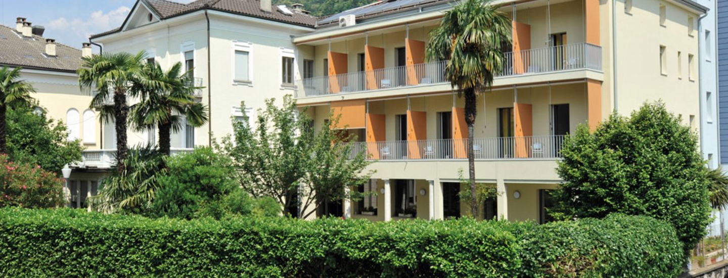 Outside view and house with palm trees Locarno Youth Hostel