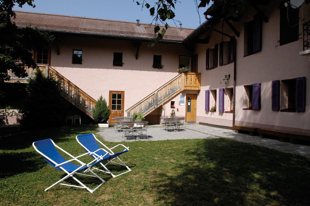 Aussenbereich Jugendherberge Château-d'Oex mit Gartenstühlen